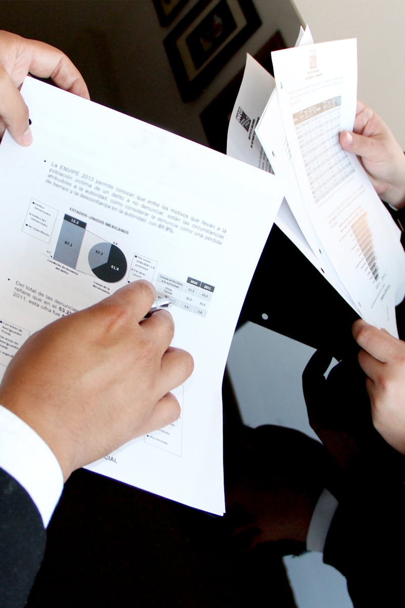 A business team reviewing charts and graphs on documents, emphasizing data analysis and teamwork.